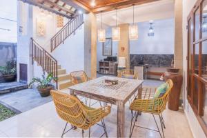 een eetkamer met een houten tafel en stoelen bij Villa Mangku in Ricefield in Ubud