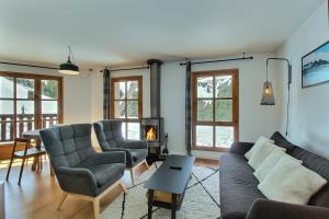 a living room with a couch and chairs and a fireplace at ARC 1950, Appartement 2 chambres, 6 personnes, Exposition Sud, SAUNA, HAMMAM, JACUZZI, PISCINE in Arc 1950