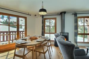 a dining room with a table and chairs and a fireplace at ARC 1950, Appartement 2 chambres, 6 personnes, Exposition Sud, SAUNA, HAMMAM, JACUZZI, PISCINE in Arc 1950