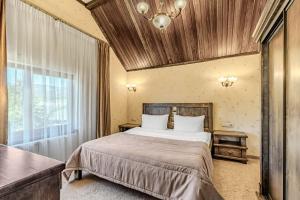 a bedroom with a large bed with a wooden ceiling at Bukovel Hotel in Bukovel +251 photos