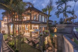 een huis met een olifantenbeeld ervoor bij Villa Mangku in Ricefield in Ubud