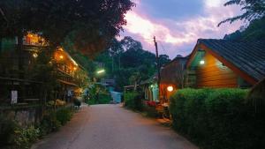 a street in a village at night with buildings at mae oui next to the water&แม่อุ๊ยที่พักติดน้ำ in Ban Pok Nai