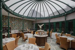 a dining room with tables and chairs and a glass ceiling at Hera Hotel in Athens