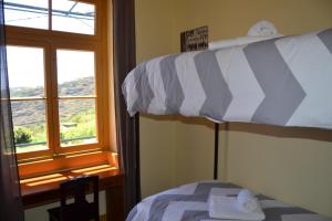 a bedroom with a bunk bed and a window at Hostel Casal São João in Ribeira Brava