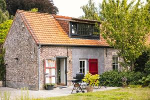 a small brick house with a red door at Authentieke schuur nabij Brugge in Beernem