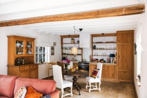 a kitchen and living room with a table and chairs at Authentieke schuur nabij Brugge in Beernem
