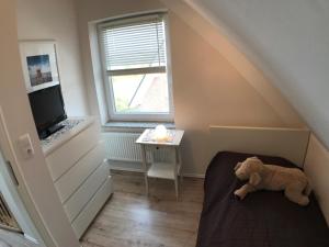 une chambre avec un lit avec un ours en peluche sur le sol dans l'établissement Kinderfreundliche Ferienwohnung NEMO für 6 Personen, à Burg