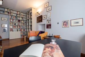 a living room with a table and bookshelves at Milan Retreats Porta Venezia in Milan
