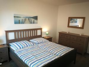 a bedroom with a bed and a painting on the wall at Nike -barrierearm- in Burg auf Fehmarn
