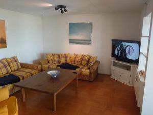 un soggiorno con due divani e una televisione di Ostsee Huus a Burg auf Fehmarn