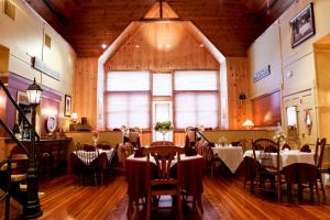 a restaurant with tables and chairs and a large window at Haven By The Sea B&B in Wells