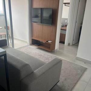 a living room with a couch and a flat screen tv at Apartamento confortável – perto do centro de Bauru in Bauru