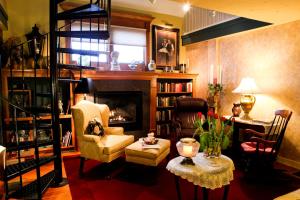 a living room with a fireplace and a chair and a table at Haven By The Sea B&B in Wells