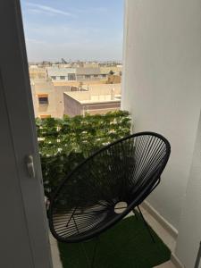 a black chair sitting on a balcony with a view at Fès comfort stay in Fès