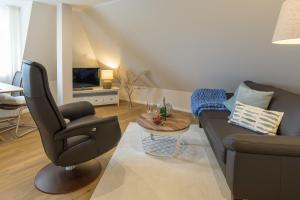 a living room with a couch and a chair at Wohnung am Binnensee in Burgstaaken