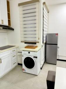 a kitchen with a washing machine and a refrigerator at Neu Suites Near KLCC in Kuala Lumpur