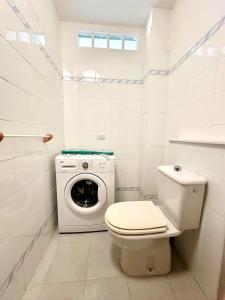 a bathroom with a toilet and a washing machine at La Casetta al mare in Stintino