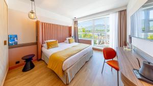 a hotel room with a bed and a large window at Le Riviera - Hôtel Restaurant & Spa - Ex Golden Tulip Aix les bains in Aix-les-Bains