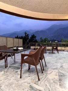 a table and chairs on a patio with a view at The lodge Guest House in Muzaffarabad +7 photos