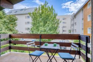 un patio avec deux chaises et une table sur un balcon dans l'établissement Alta House - Central Ferney and Family-Friendly, à Ferney-Voltaire