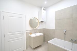 a white bathroom with a sink and a mirror at Apartment Grace Family in Vienna