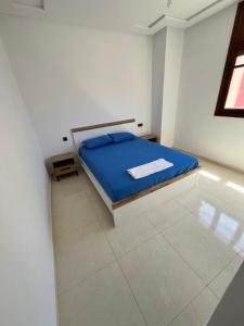a bedroom with a bed with a blue blanket at La Casa Luminosa 5 in Larache