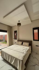 ein großes Bett in einem Schlafzimmer mit großem Fenster in der Unterkunft Villa Araucaria, idéale pour vos vacances en famille in Riaïna