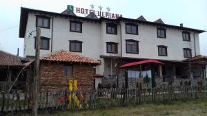 a large white building with a fence in front of it at Hotel Ulpiana, Ethno House in Gracanica