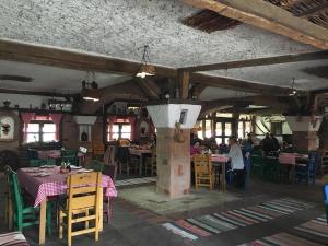 a restaurant with tables and chairs and people sitting at tables at Hotel Ulpiana, Ethno House in Gracanica