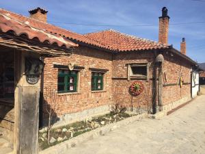 a brick building with windows and a wreath on it at Hotel Ulpiana, Ethno House in Gracanica