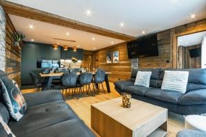 een woonkamer met een bank en een tafel bij CHALET TEKA LES GETS - Appartement Chery in Les Gets