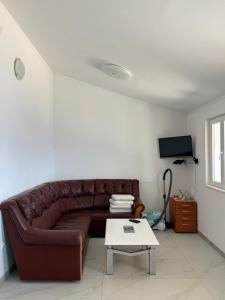 a living room with a brown leather couch and a table at Beach house Korina in Sveta Nedelja