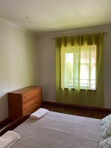 a bedroom with a bed and a dresser and a window at Apartamento Esmoriz in Esmoriz +16 photos