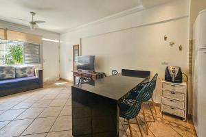 a kitchen with a counter and chairs in a room at 1E - Pe na Areia da Praia do Tombo, 3 Quartos, Ar Cond, 2 WC, 1 vaga e Roupas de Cama in Guarujá +47 photos