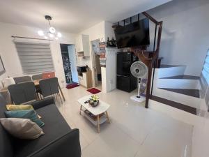 a living room with a couch and a tv at Two-Bedroom Townhouse Camella Bacolod South in Bacolod