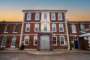 a large brick building with a sign in front of it at Park Hall Hotel and Spa Wolverhampton in Wolverhampton