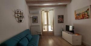 a living room with a blue couch and a television at Casa Don Raffaele in Agira +19 photos