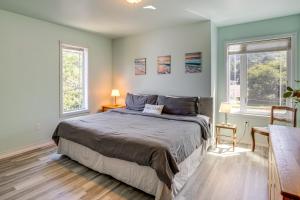 Un dormitorio con una cama grande y dos ventanas. en Walk to Shore Home with Deck in Rockaway Beach!, en Rockaway Beach