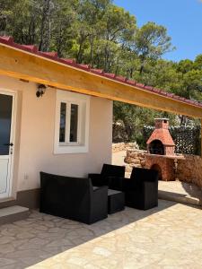 a patio with couches and a fireplace in front of a house at Beach house Korina in Sveta Nedelja +18 photos