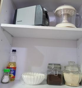 a refrigerator shelf with a toaster and other kitchen items at Central and cozy apartment in Mexico City