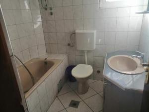 a bathroom with a tub and a toilet and a sink at Vila Bula 1 in Donji Štoj