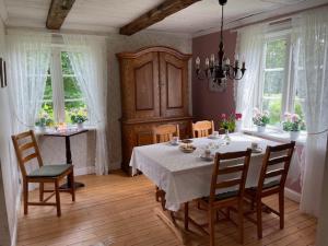 a dining room with a table and chairs and windows at Skeens Nygård in Skeen