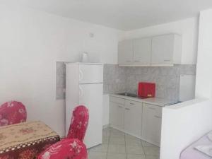 a kitchen with a red chair and a white refrigerator at Vila Bula 1 in Donji Štoj +12 photos
