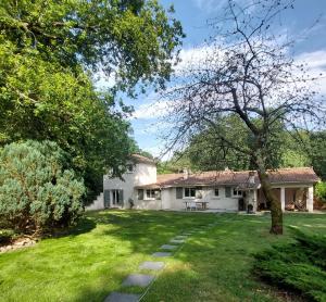 a large white house with a yard and trees at Clos des Loriots in Queyrac