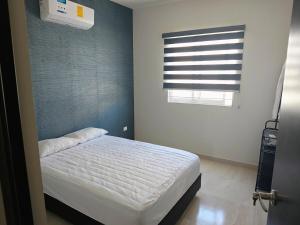 a bedroom with a white bed and a window at Casa Cerca del Cerro la Memoria in Los Mochis +4 photos