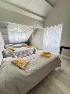 a bedroom with two beds with yellow pillows on them at Casa en Cumbres in Ushuaia
