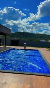 a large blue swimming pool on top of a building at A Casa Luxo Piscina Enorme Vista Serra de Caldas in Caldas Novas