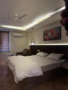 a bedroom with a large bed and a living room at Luxury stayz in Greater Noida