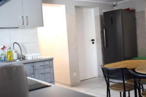 a kitchen with a table and a refrigerator at 2 Cozy Apartment Bialystok in Białystok +6 photos
