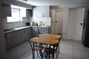 a kitchen with a wooden table and some chairs at 2 Cozy Apartment Bialystok in Białystok